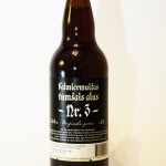 A dark brown glass bottle of "Valmiermuižas Tumšais Alus Nr. 3" placed against a white background. The label features white gothic text and includes details about the beer's origin and ingredients. A white barcode is visible at the bottom of the label.